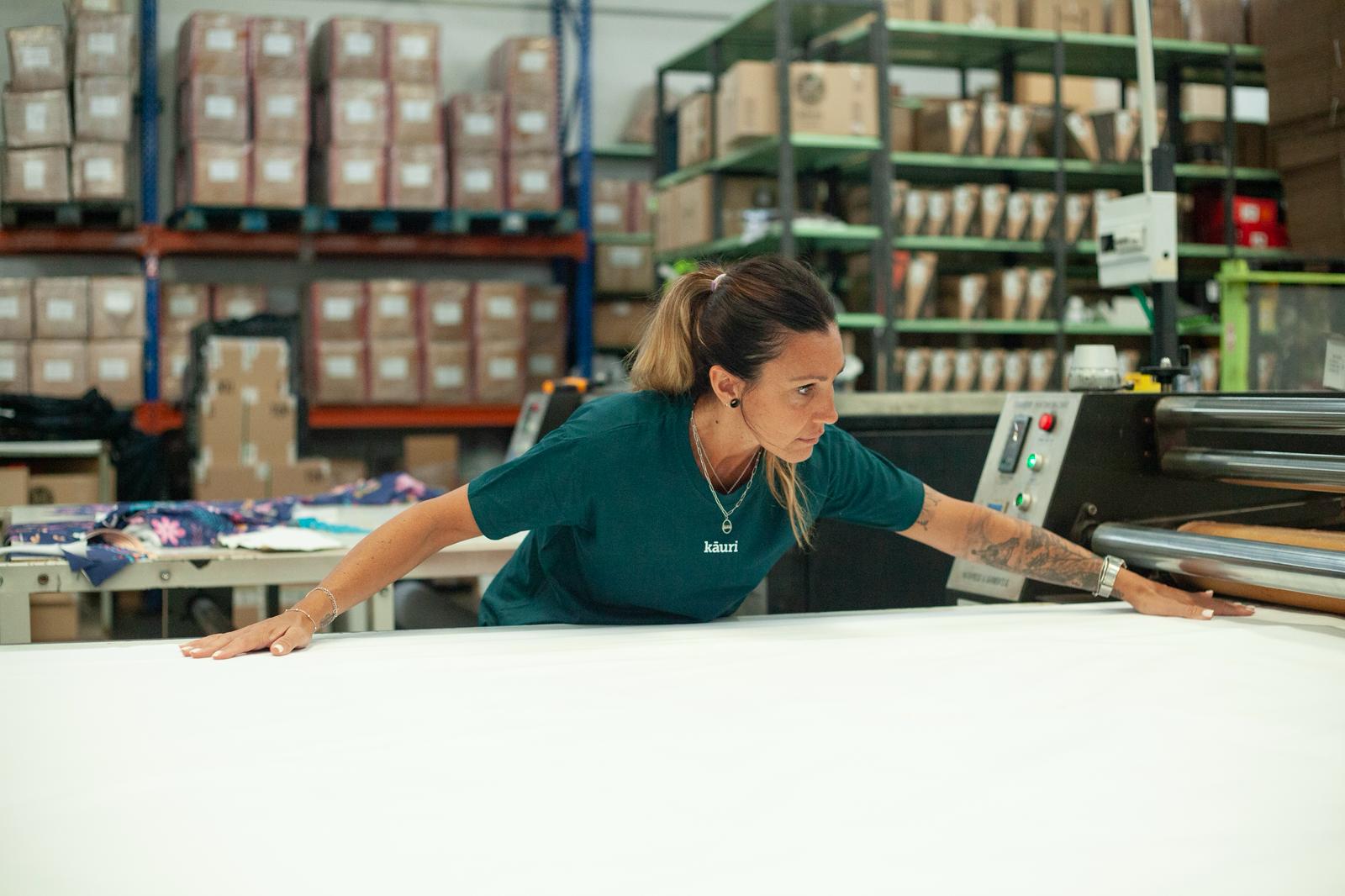 Máquina calandra de producción textil en las instalaciones de DRESSCO en Silla, Valencia — personalización de ropa de trabajo
